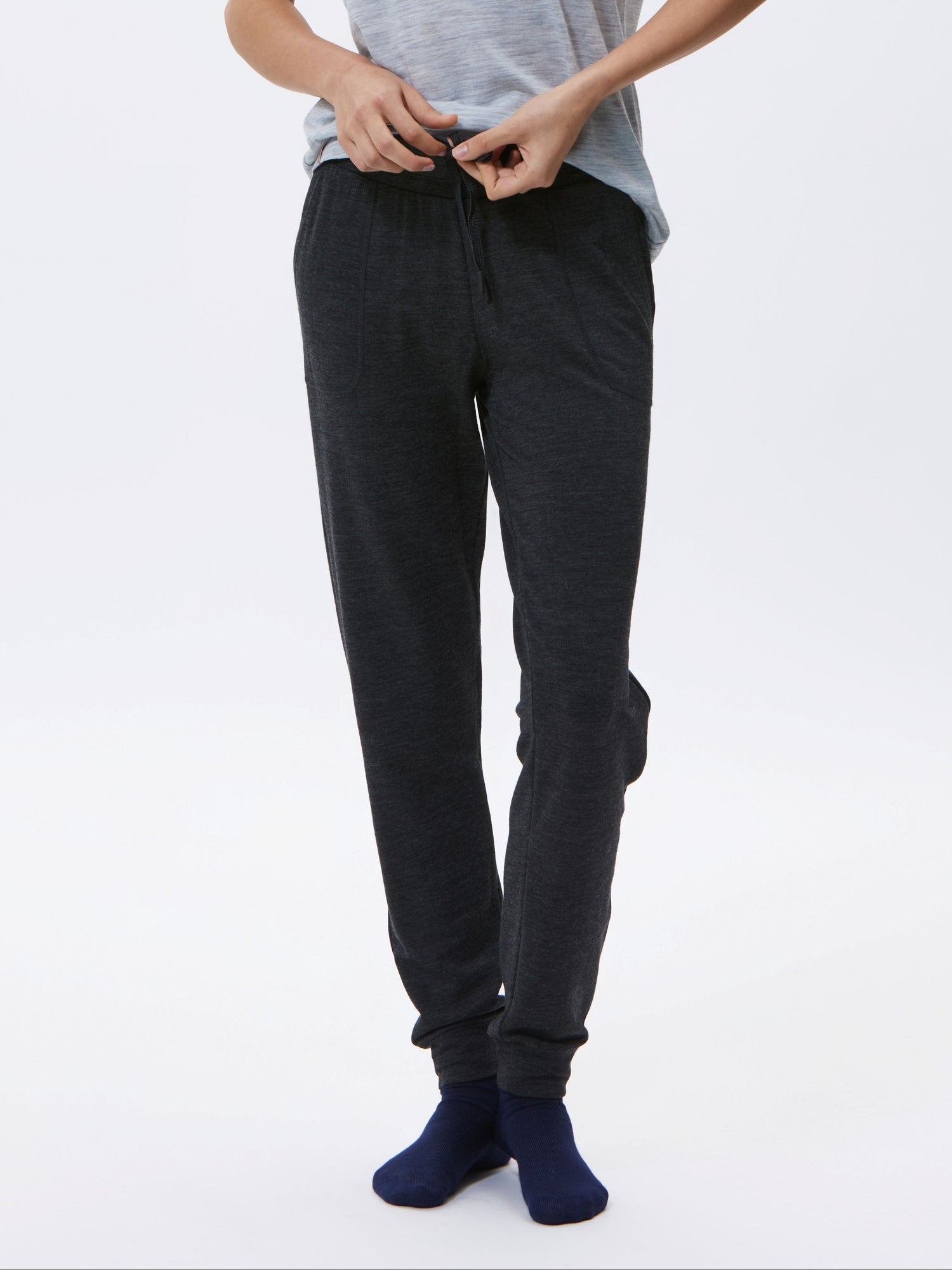 Woman wearing a gray t-shirt and charcoal pants on a white background