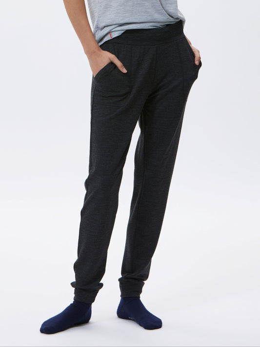 Woman wearing a gray t-shirt and charcoal pants on a white background